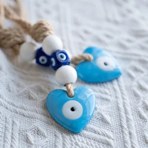 Detail of heart-shaped evil eye pendants with blue nazar charms and natural jute rope