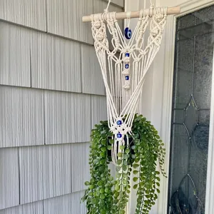Bohemian macrame plant hanger with blue evil eye beads and wood rod wall decor