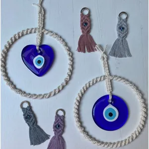 Decorazione da parete Evil Eye in macramè e portachiavi con nappe su legno bianco