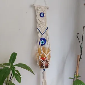 Handmade macrame boho wall hanging with blue evil eye beads and glass candle holder