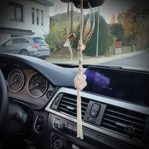 Detail of macrame rearview mirror pendant with pink healing crystal and feathers