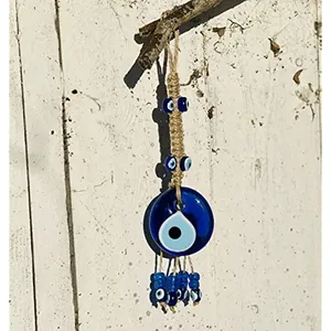 Blue Turkish Evil Eye glass pendant with woven rope hanging on a wooden branch