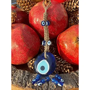 Detail of handmade Turkish evil eye glass pendant with rustic jute rope weaving decor