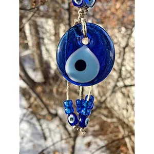 Close-up of blue glass evil eye nazar charm with rustic twine and decorative beads