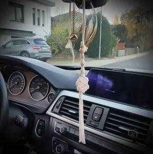 Detail of macrame car charm with pink salt crystal and brown feathers on mirror