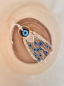 Detail of macrame blue evil eye wall hanging with wooden alphabet beads and fringe