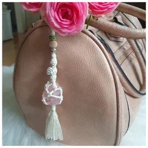 Detailed macro view of handmade macrame crystal hanger with pink stone and heart charm