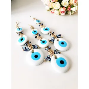 Detailed close-up of three handcrafted blue glass evil eye hanging ornaments on white surface