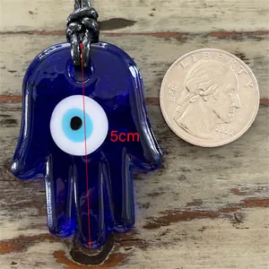 Vue détaillée d'un pendentif Hamsa de 5cm en verre bleu avec l'œil de protection