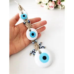 Detailed view of Turkish Evil Eye glass charms on hand-woven rope for car hanging decor