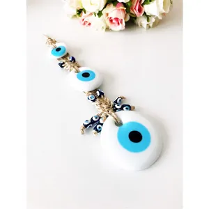Detailed view of handcrafted evil eye wall hanging with layered blue glass beads