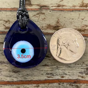 Vue détaillée du pendentif œil bleu de 3,5 cm en verre sur fond bois vintage