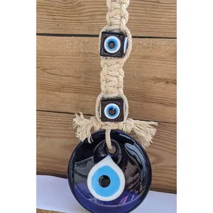 Close-up of handmade Macramé cotton knotting and glass blue Evil Eye pendant details