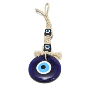 Macro detail of handmade woven cotton rope with evil eye glass pendant and black beads