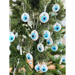 Dettaglio di ornamenti in vetro Malocchio appesi a un ramo di albero di Natale