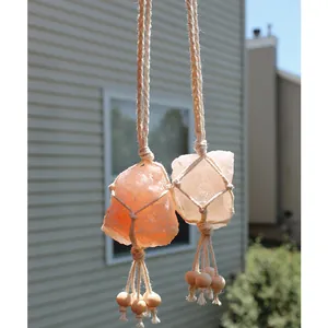 Close-up of Himalayan pink salt stones in handmade macrame woven netting with tassels