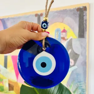 Détail du pendentif turc mauvais œil en verre avec perles dorées et attache en corde