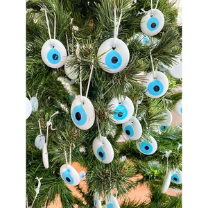 Ornamenti malocchio in vetro blu su un albero di Natale con corde in cotone