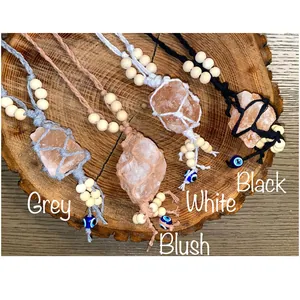 Detailed view of handmade woven cotton hangers with raw pink salt stones and evil eye beads