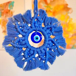 Macro detail of hand-woven blue cotton fibers with a Turkish Evil Eye glass bead