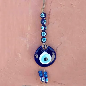 Dettaglio dell'occhio di Allah in vetro con perline blu su superficie di roccia naturale