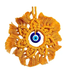 Handmade macrame evil eye wall hanging in yellow cotton with fringe and lucky bead charm