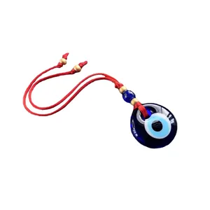 Handgemaakte Evil Eye hanger met blauw glas en rood touw voor wand- of autodecoratie