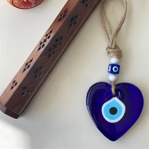 Detail view of heart-shaped blue evil eye glass pendant with natural jute rope and beads