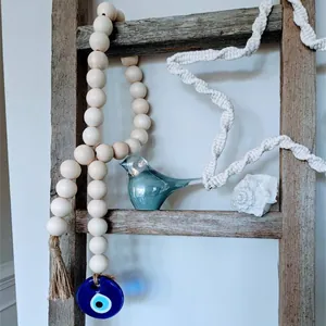 Bohemian wood bead garland with evil eye glass pendant and jute tassel wall decor