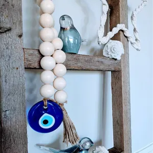 Bohemian wood bead garland with blue Evil Eye glass pendant and rustic jute tassel decor