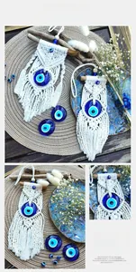 Detail of handcrafted macrame evil eye wall hanging with beads and wooden rod decor