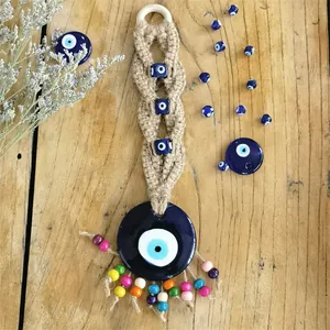 Detailansicht eines handgefertigten Evil Eye Wandschmucks aus Jute und blauem Glas