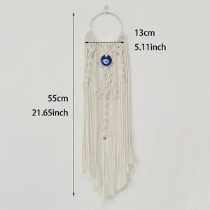 Macro detail of handmade woven bohemian evil eye tapestry with long cotton tassels