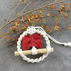 Close-up of handmade macrame Christmas ornament with red and white cotton rope and snowflake