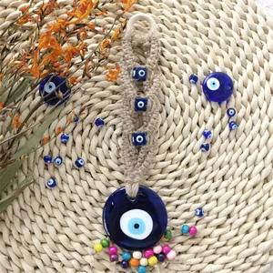 Detail eines handgefertigten Evil Eye Anhängers mit Juteseil und blauen Glasperlen