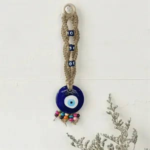 Handgefertigter Evil Eye Wandbehang mit gewebtem Hanfseil und blauem Glas-Talisman