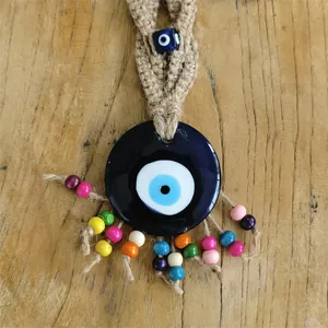 Detailaufnahme des handgefertigten Evil Eye Wandbehangs mit Juteseil und bunten Perlen