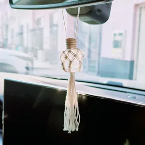 Detail of bohemian hand-woven cotton net and wood cap on glass perfume bottle car charm