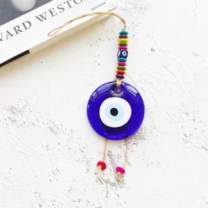 Detail of handmade evil eye pendant featuring vibrant beads and rustic hemp rope hanger