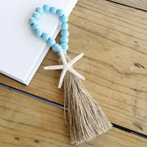 Detailed view of light blue wooden beads and hemp tassel with white starfish decor