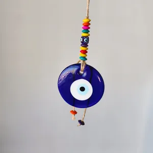 Detail of blue glass Evil Eye pendant with colorful beads and natural jute rope