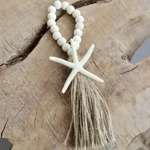 Detailed view of handmade white wood beads with starfish and natural jute tassel