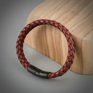 Détail d'un bracelet en cuir tressé rouge foncé avec fermoir magnétique noir mat