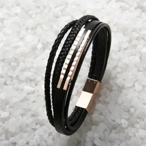 Détail d'un bracelet multicouche en cuir tressé noir avec fermoir magnétique en or rose