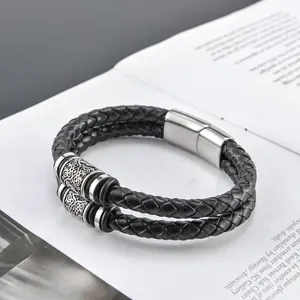 Detail eines geflochtenen Lederarmbands für Herren mit Wikinger-Metallelementen und Magnetverschluss