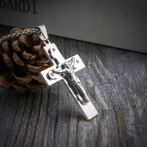 Macro-opname van zilveren roestvrijstalen crucifix-hanger op donker hout met dennenappel