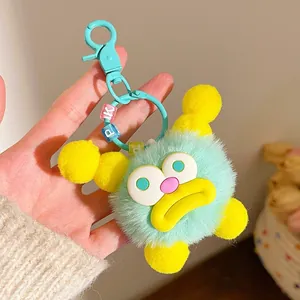 Cute mint green plush monster keychain with yellow accents and colorful letter beads