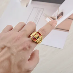 Macro detail of men's vintage class ring with golden lion crest and red gemstone