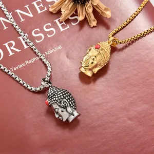 Detailed macro view of gold and silver Buddha head pendants with red bead accents