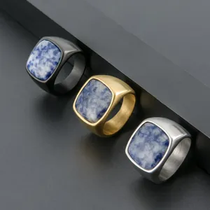 Detalle de anillos con piedra azul cuadrada en acero cepillado negro, dorado y plata